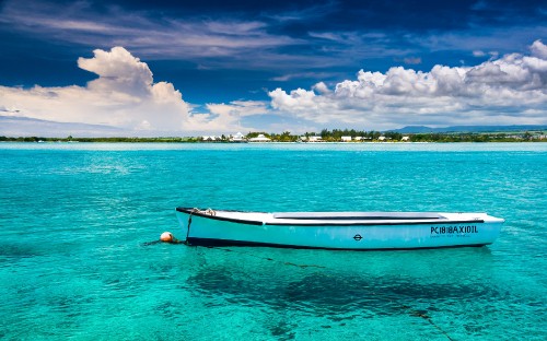 Image white and brown boat on blue sea under blue and white cloudy sky during daytime