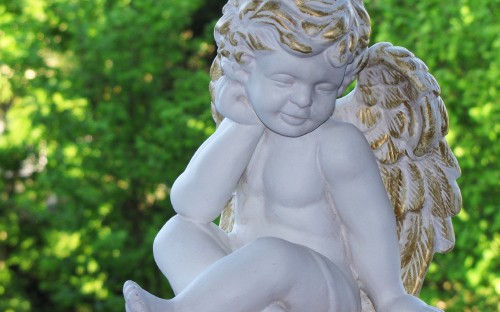 Image angel statue near green grass during daytime