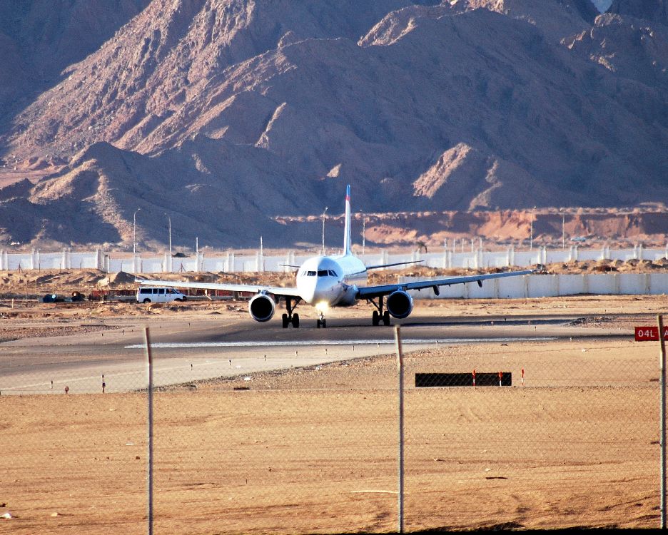 white airplane on gray concrete road during daytime