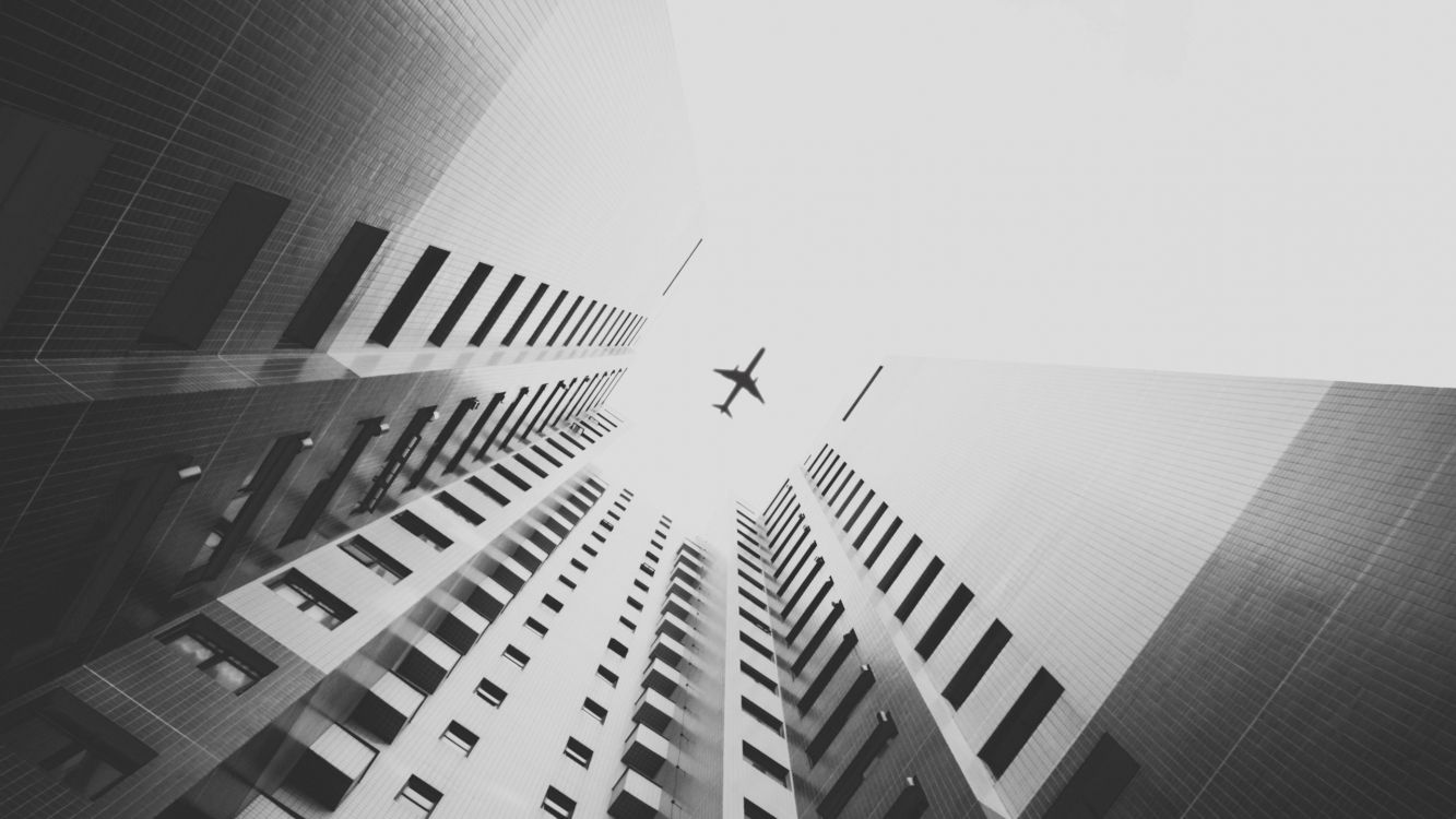 Foto en Escala de Grises de un Avión en el Aire Sobre un Edificio de Gran Altura. Wallpaper in 2560x1440 Resolution