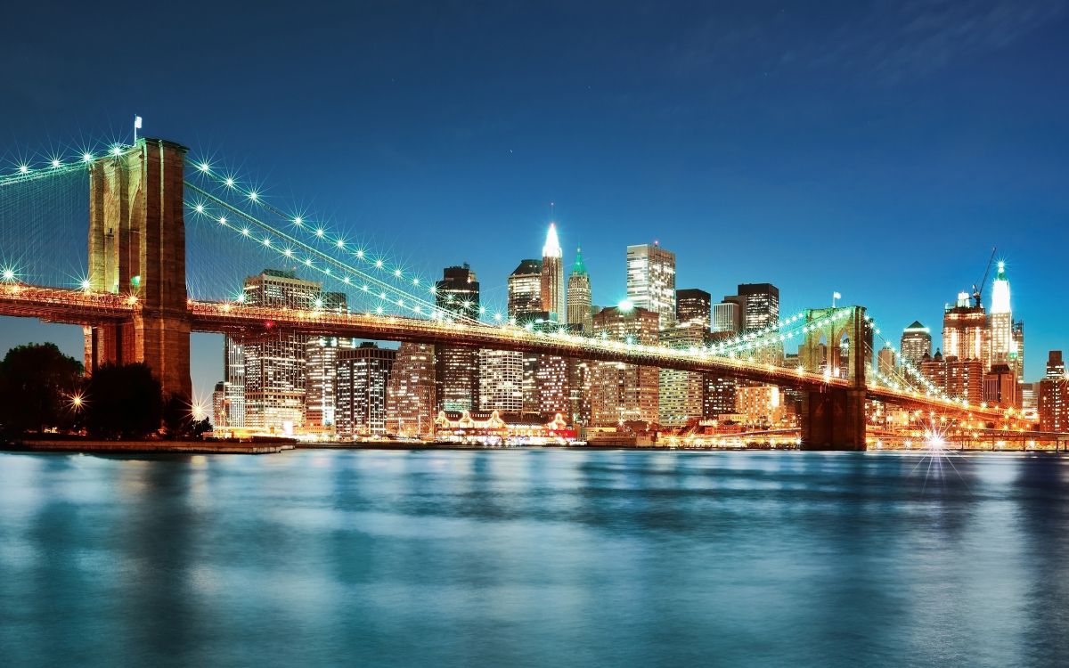 lighted bridge over water during night time