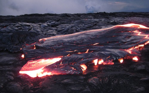 Image burning wood on rocky ground during daytime