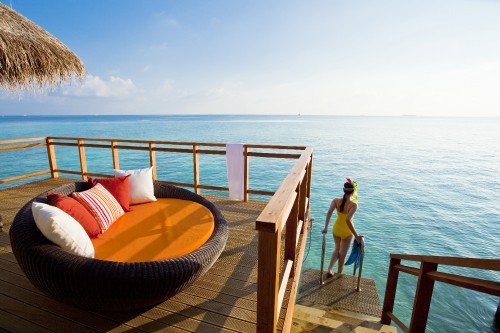 Image woman in blue bikini sitting on brown wooden bench near sea during daytime