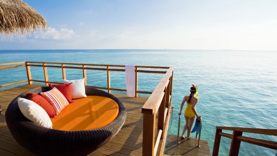 Image woman in blue bikini sitting on brown wooden bench near sea during daytime