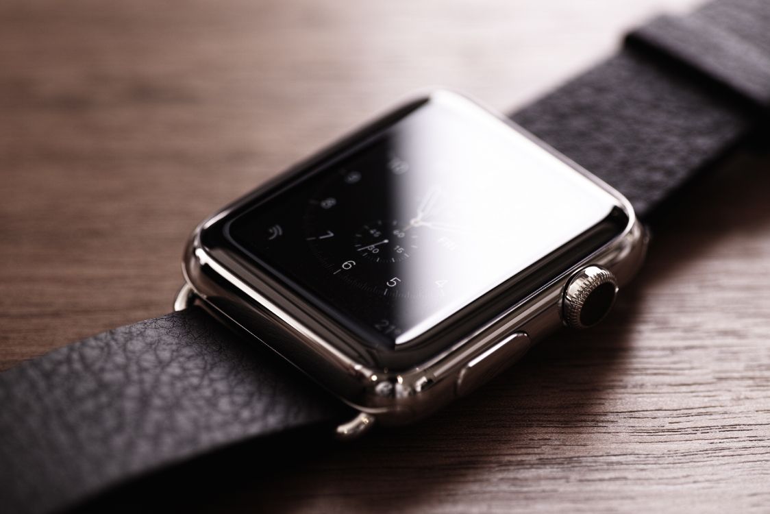 silver apple watch on brown wooden table