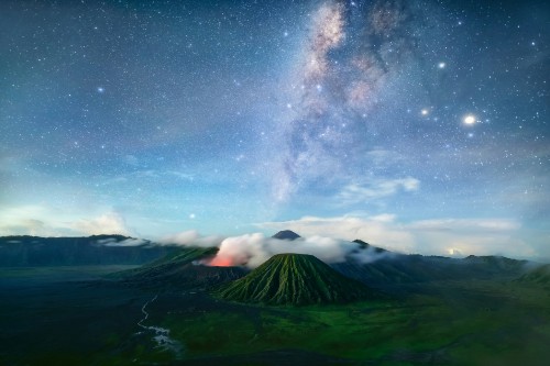 Image green mountain under blue sky with stars during night time