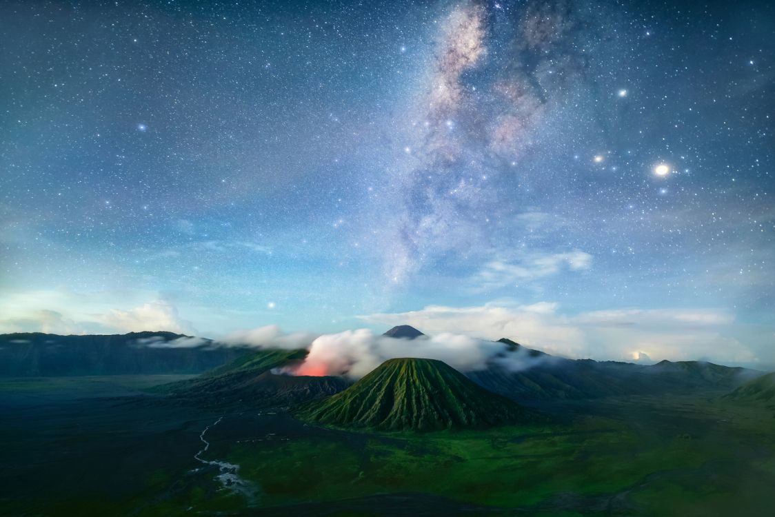 green mountain under blue sky with stars during night time