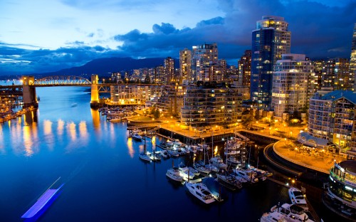 Image city skyline across body of water during night time