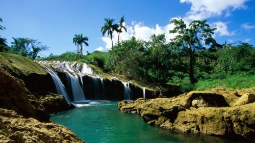 Image waterfalls near green trees under blue sky during daytime