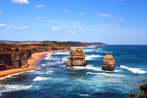 Image brown rock formation on sea under blue sky during daytime