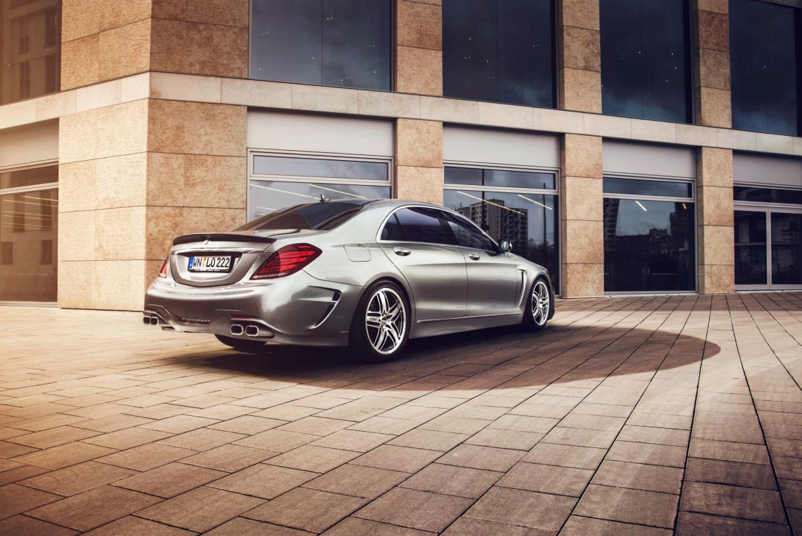 silver mercedes benz coupe parked beside brown brick building