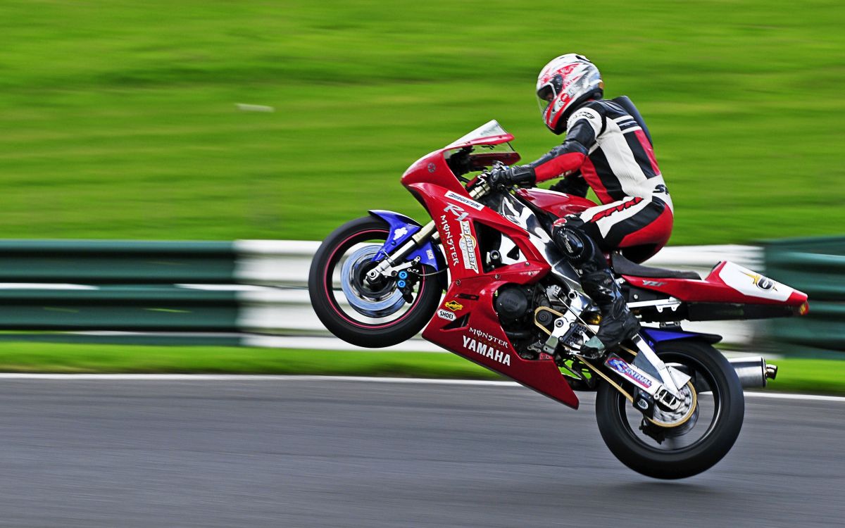 Man in Red and Black Motorcycle Suit Riding on Red Sports Bike. Wallpaper in 2560x1600 Resolution