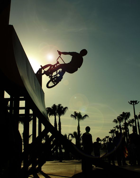 silhouette of man playing basketball during sunset