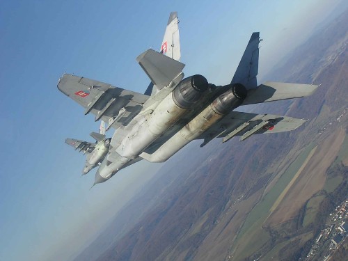 Image gray fighter jet flying over the mountain during daytime