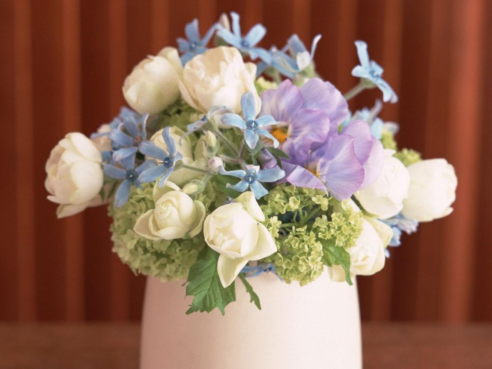 white and purple flowers in white ceramic vase