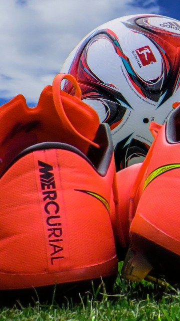 Image orange and white nike athletic shoes on green grass during daytime
