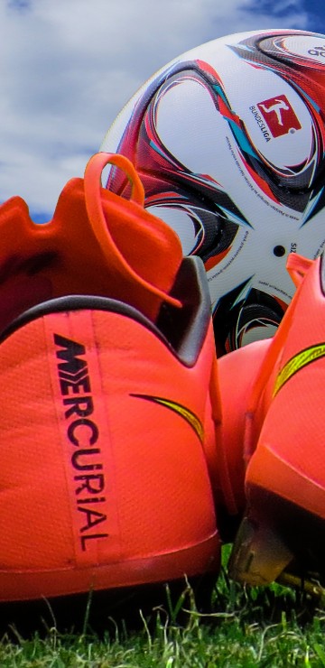 Image orange and white nike athletic shoes on green grass during daytime