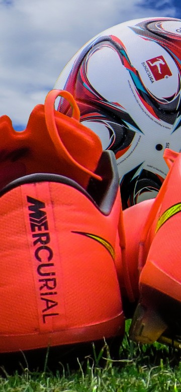 Image orange and white nike athletic shoes on green grass during daytime