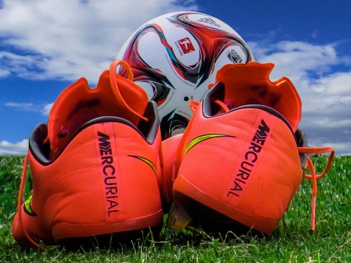 Image orange and white nike athletic shoes on green grass during daytime