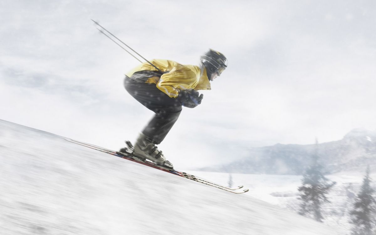 man in yellow jacket and blue denim jeans riding ski blades on snow covered ground during