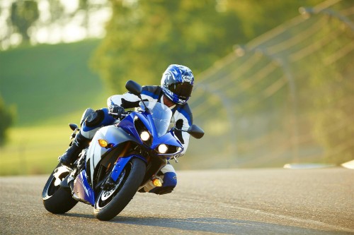 Image man in blue and white motorcycle suit riding on black sports bike during daytime