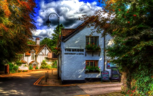 Image white and brown wooden house near trees under blue sky during daytime