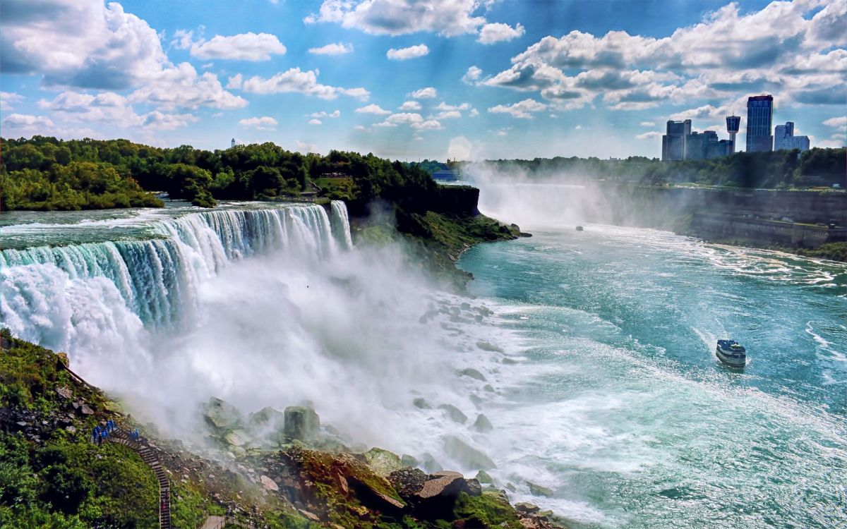 waterfalls under blue sky and white clouds during daytime