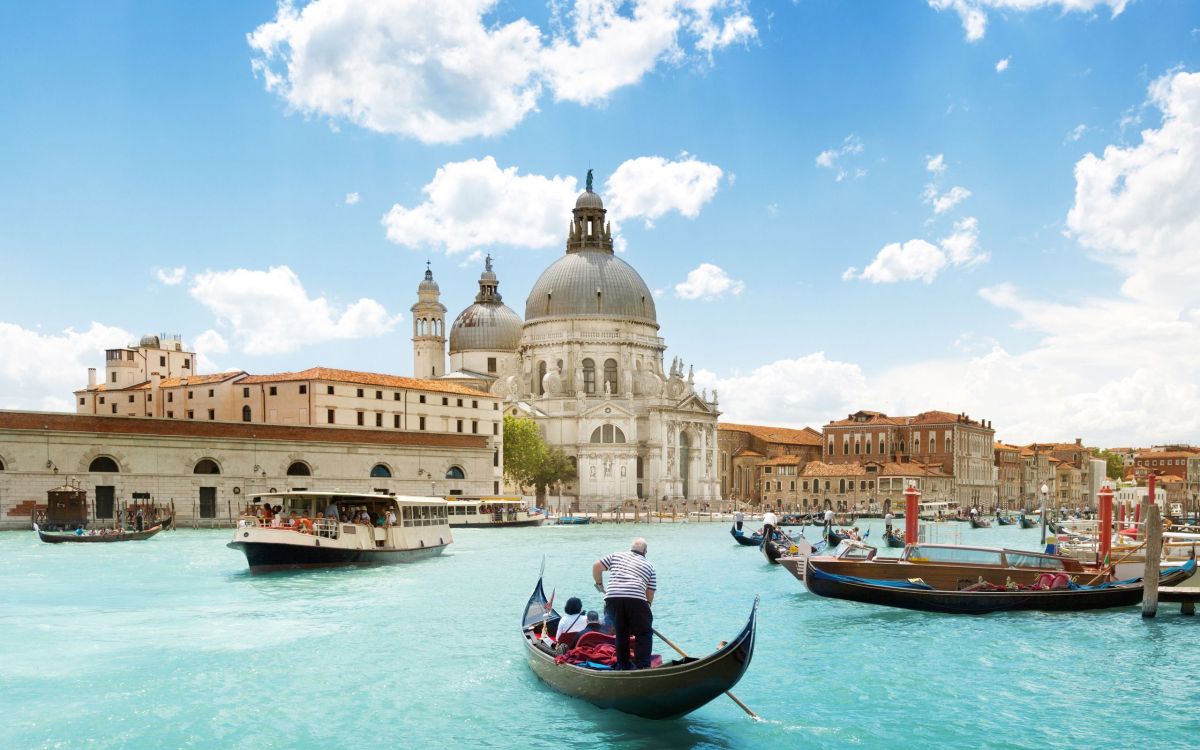 people riding on boat near brown concrete building during daytime