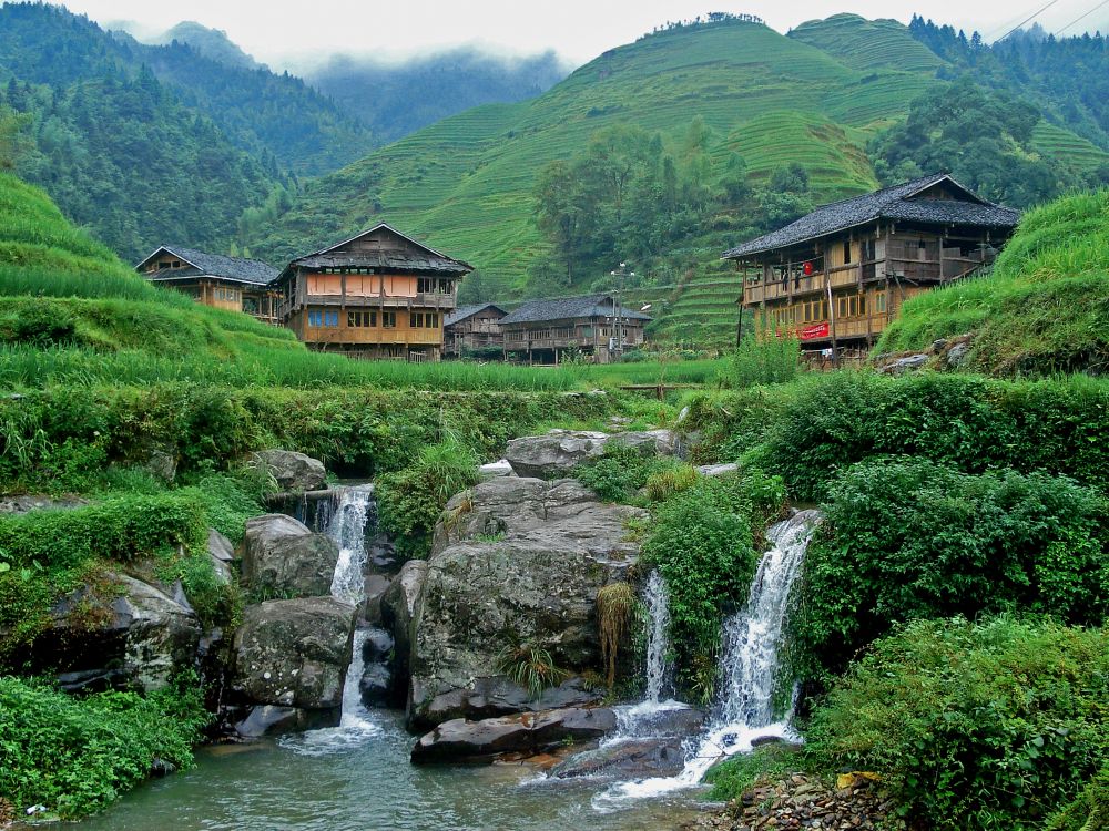 brown wooden house near water falls during daytime