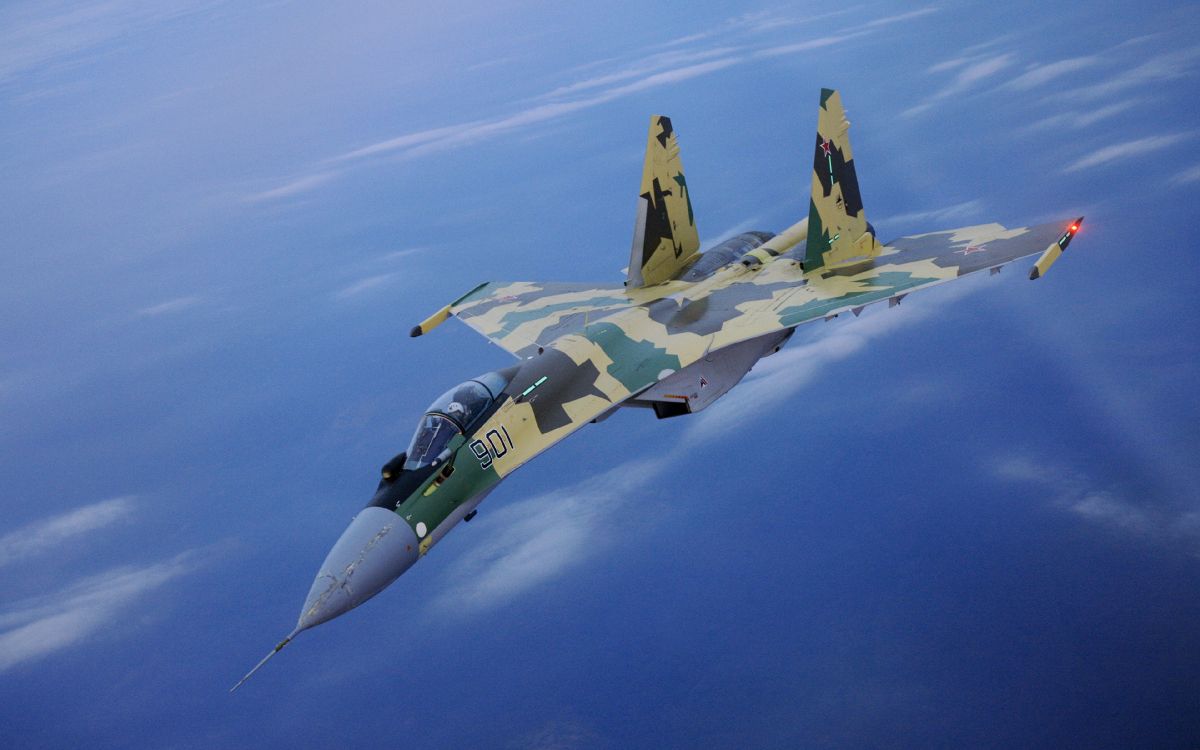 green and black fighter jet flying in the sky during daytime