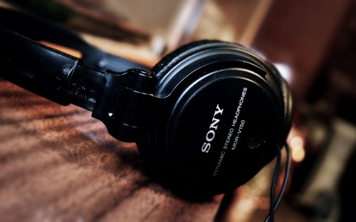 Image black sony headphones on brown wooden table