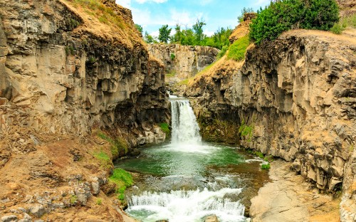 Image waterfalls on brown rocky mountain under blue sky during daytime