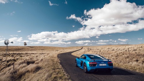 Image blue audi r 8 on brown field under blue and white cloudy sky during daytime