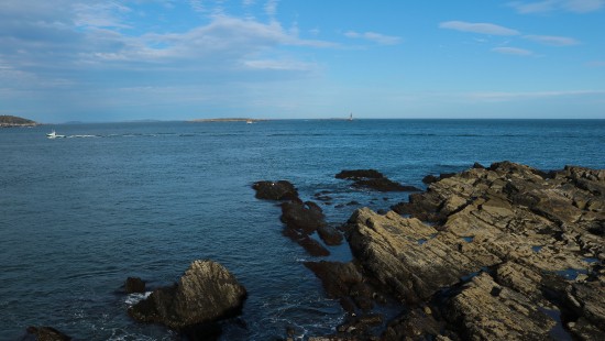 Image brown rocks on sea under blue sky during daytime