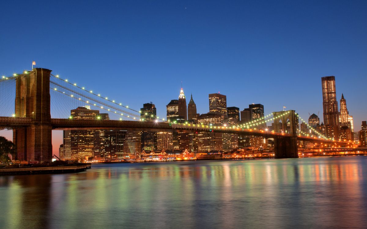 lighted bridge over water during night time