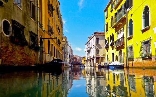 Image river between concrete buildings under blue sky during daytime