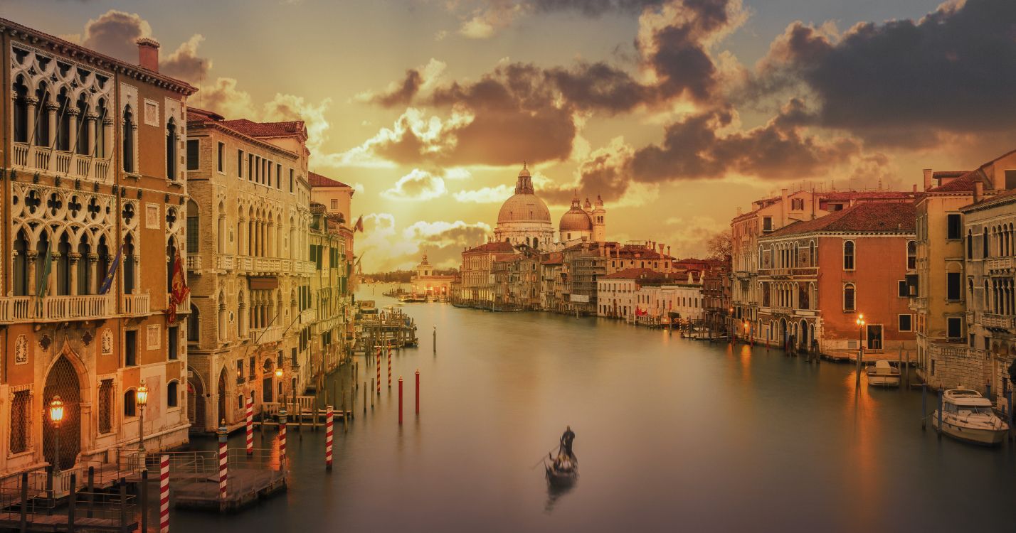 boat on water near buildings during sunset