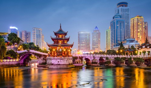 Image city skyline across body of water during night time