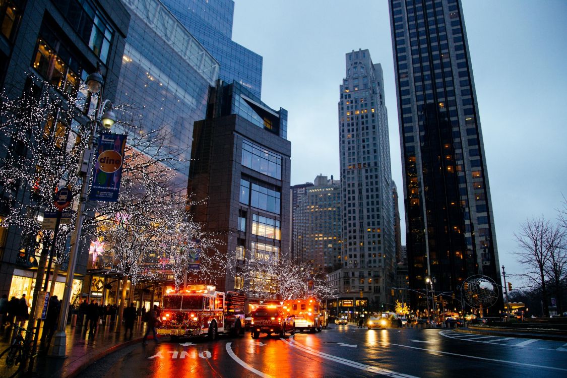 cars on road near high rise buildings during night time