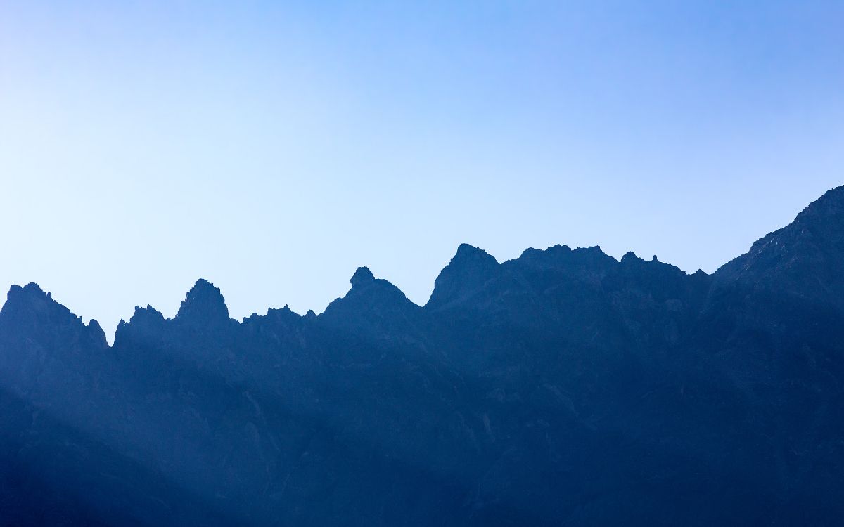 Tagsüber Schwarze Berge Unter Blauem Himmel. Wallpaper in 5184x3240 Resolution