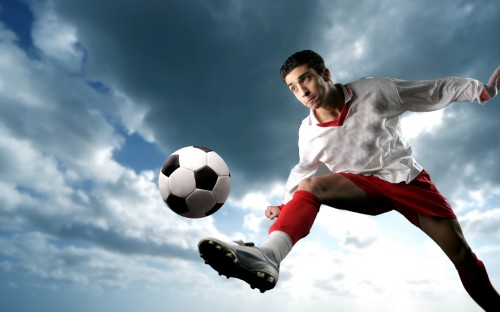 Image man in white shirt and red shorts playing soccer