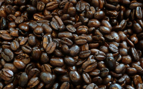 Image brown coffee beans on black surface