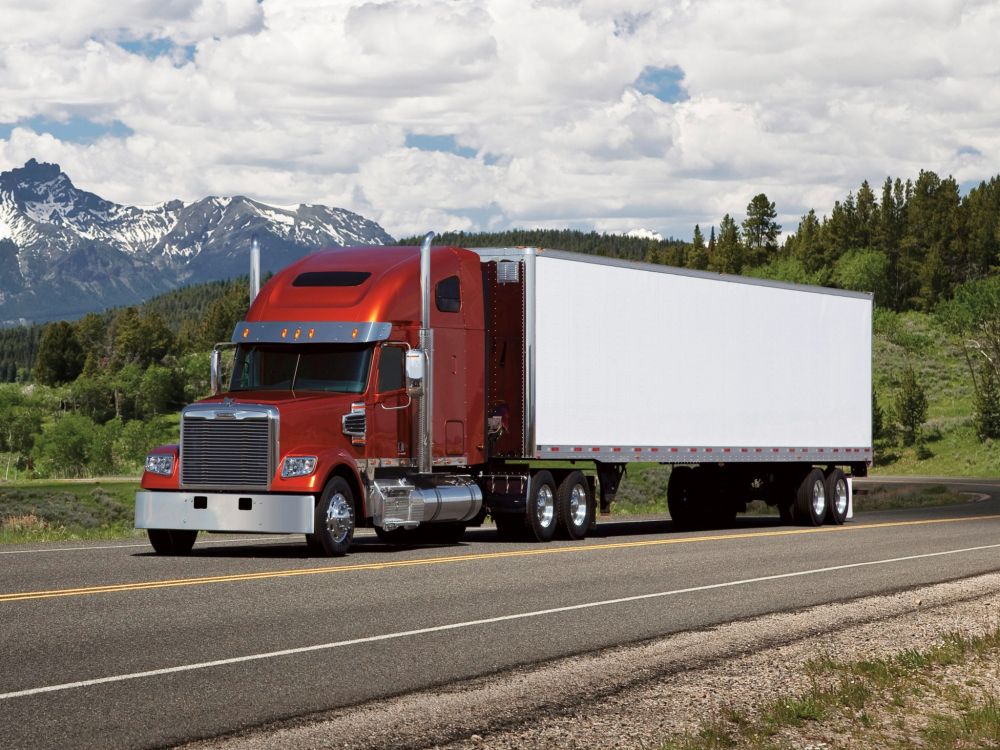 red and white freight truck on road during daytime