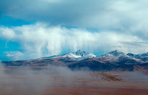 Image snow covered mountain under cloudy sky during daytime