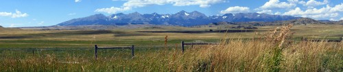 Image brown wooden fence on green grass field near mountains during daytime