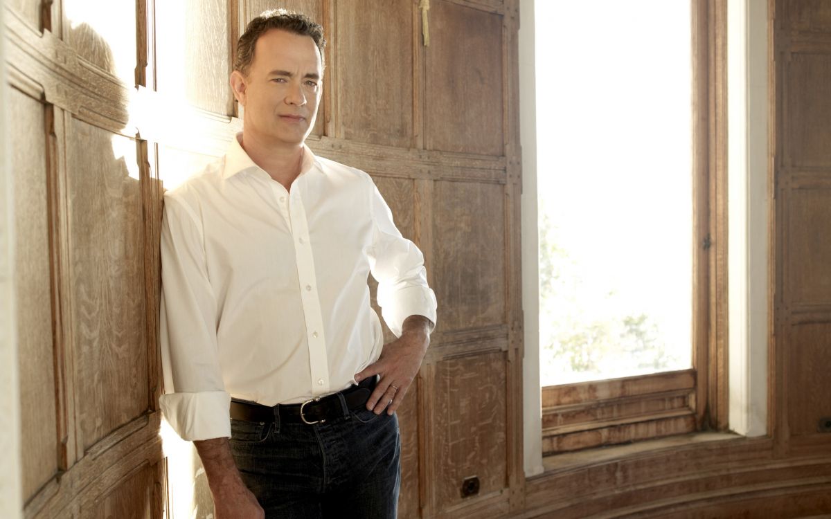 man in white dress shirt and blue denim jeans standing near brown wooden door during daytime