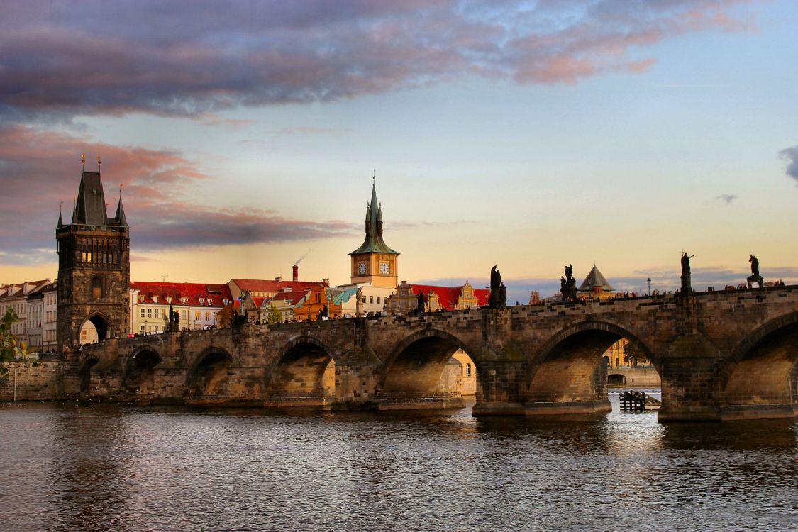 brown concrete bridge over river during sunset