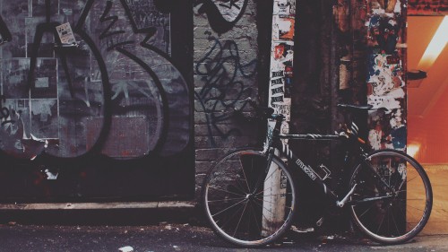 Image black and white bicycle parked beside black and white wall