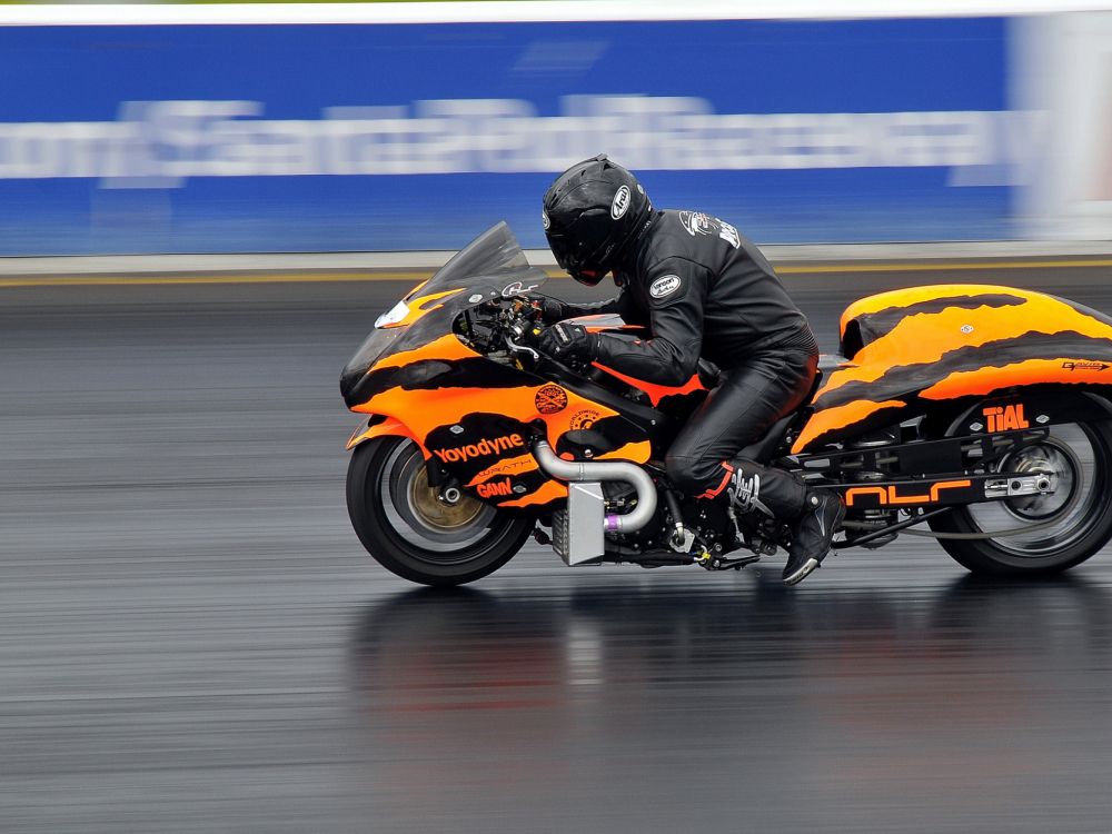 Hombre de Chaqueta Negra Montando Bicicleta Deportiva Naranja. Wallpaper in 2048x1536 Resolution