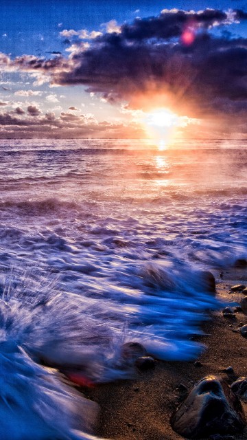 Image sea waves crashing on shore during sunset